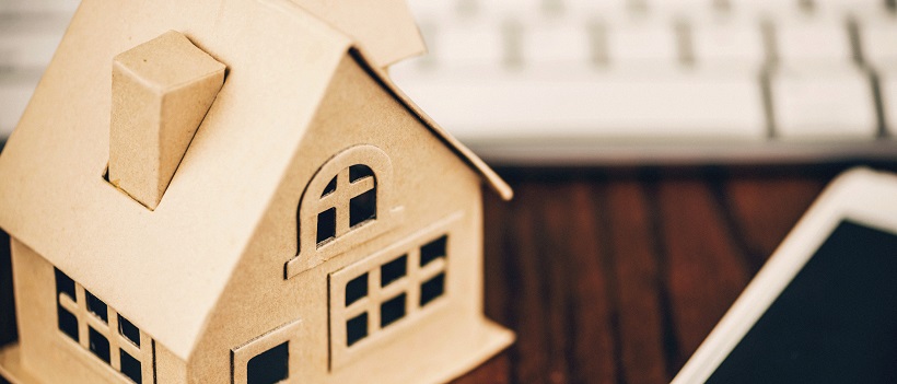 House model on desk with keyboard and smart phone