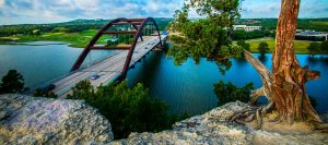 View of the Pennybacker Bridge stretching across the calm, blue waters of Lake Austin.