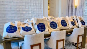 Multiple Milky Way at River Place themed gift tote bags sitting on top of a table for guests to grab as a gift.