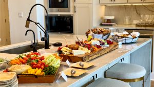 A delicious arrangement of a wide variety of cheese, crackers, bread, fruit, nuts, and snacks on top of a table for guests to snack on while celebrating the grand opening of Milky Way at River Place.